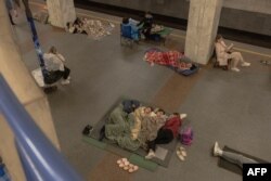 Oameni din Kiev se adăpostesc într-o stație de metrou în timpul atacurilor aeriene rusești, pe 21 august 2025.