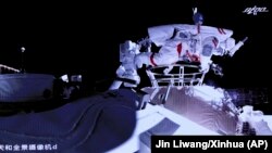 Китайські космонавти під час робіт на зовнішній стороні станції