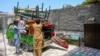 Afghan refugees load their belongings onto a truck in Peshawar, Pakistan, on July 13 as they prepare to depart for Afghanistan.