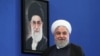 Iranian President Hassan Rouhani pictured in front of a portrait of Supreme Leader Ali Khamenei, October 14, 2019