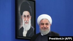 Iranian President Hassan Rouhani pictured in front of a portrait of Supreme Leader Ali Khamenei, October 14, 2019