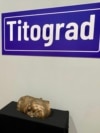 Pad socijalizma i formiranje novih nacionalnih država ogledali su se i kroz preimenovanjima ulica i trgova. Dok su se u gradovima Istre, Slovenije, Crne Gore i Makedonije zadržali nazivi po Josipu Brozu Titu, u drugim dijelovima bivše Jugoslavije njegovo ime brzo je uklonjeno sa mapa. <br><br>U Beogradu je Titova ulica prvo preimenovana u Ulicu srpskih vladara, a zatim u Ulicu kralja Milana. Istovremeno nakon 1990. godine, zabilježeno je masovno uklanjanje i uništavanje spomenika. <br><br>Na izložbi je istaknut prepolovljeni spomenik Josipu Brozu Titu, vođi partizanskog pokreta i doživotnom predsjedniku Jugoslavije.
