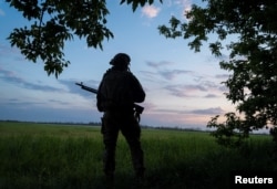 Un militar ucrainean păzește o zonă din apropierea orașului Vovchansk.