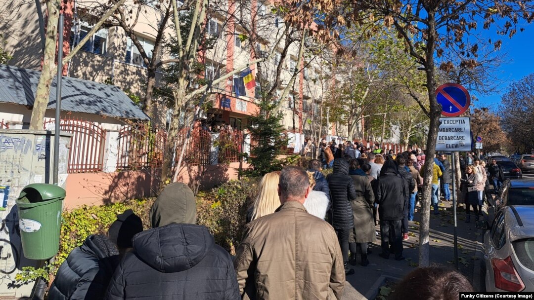 Câteva zeci de persoane stăteau la coadă la secția de vot amenjată la Școala Generală Herăstrău, duminică 24 noiembrie, la prânz.