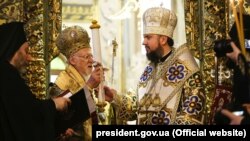 Вселенський патріарх Варфоломій (л) вручає сувій із томосом голові УПЦ митрополитові Епіфанію (п), Фанар, Стамбул, 6 січня 2019 року