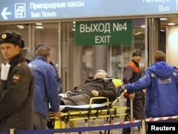 O victimă este scoasă pe targă de medici la aeroportul Domodedovo din Moscova, după un atac sinucigaș la 24 ianuarie 2011, care a ucis 37 de persoane.