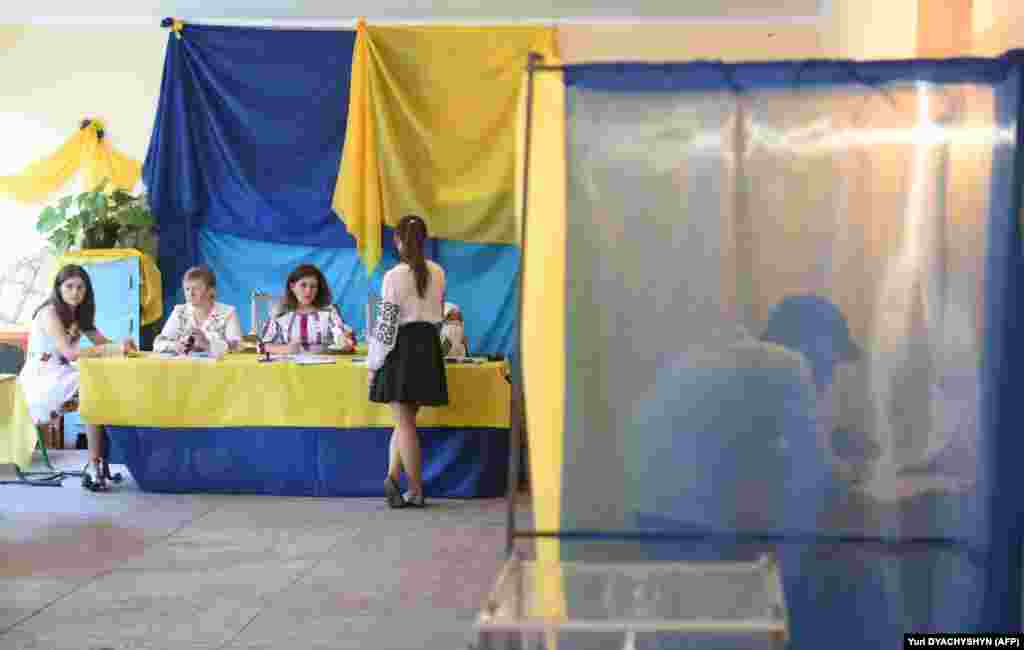A man fills in his ballot inside a voting booth at a polling station in the village of Mshana, some 15 kilometres from the western city of Lviv. Only 424 of the 450 seats in Ukraine's parliament will be filled in these elections, as the rest represent Crimea, annexed by Russia in 2014, or territories controlled by Russia-backed separatists. (AFP/ Yuri Dyachyshyn)