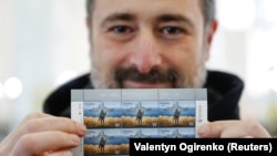 Игорь Смелянский показывает почтовые марки «Русский военный корабль, иди…! Героям слава!»