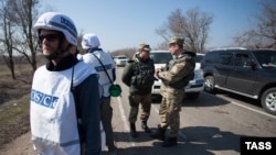 Співробітники ОБСЄ, а також українські і російські представники в Спільному центрі контролю і координації режиму припинення вогню в селищі Широкине, 25 березня 2015 року