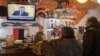 Ukrainians react as they watch a TV broadcast of ousted Ukrainian President Viktor Yanukovych's press conference on February 28.