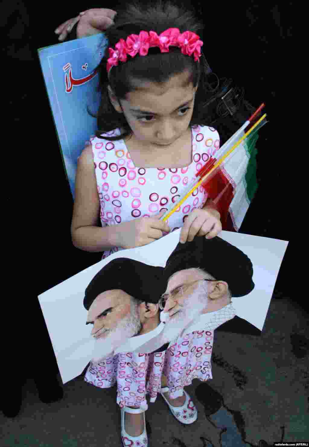 A small girl holds posters of Ayatollah Ali Khamenei and Ayatollah Ruhollah Khomeni with Iranian flag as she waits for the convoy of Iran's President Mahmud Ahmadinejad in Beirut on October 13. Photo by Mohammad Reza Hassani for RFE/RL's Radio Farda