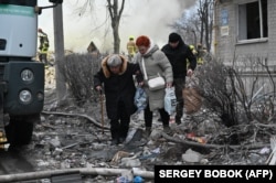 Residents leave the area after a five-story residential building was hit by a ballistic missile in Kharkiv amid the Russian invasion of Ukraine in early March.
