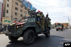 A member of the Iraqi security forces flashes the victory sign during a military parade marking the withdrawal of the US-led coalition from Iraq, in Baghdad on September 30.