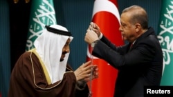 Tayyip Erdogan (sağda) Səudiyyə kralı Salmana medal verir (Arxiv)