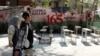 Iranian women walk past a symbolic Minab school, referring to the school targeted in a February air strike that killed 120 schoolchildren, in Tehran in April. 