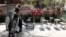 Iranian women walk past a symbolic Minab school, referring to the school targeted in a February air strike that killed 120 schoolchildren, in Tehran in April. 