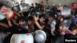 Palestinci čekaju na hranu koju je osigurala dobrotvorna kuhinja, u gradu Gazi, 21. maja 2025.