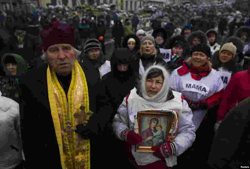 Людзі сьпяваюць рэлігійныя гімны ў лягеры антыўрадавых пратэстоўцаў каля Кіева.