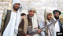 Surrendering Taliban militant fighters stand with their weapons as they are presented to the media at a government building in Herat in November 2008.