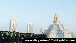 Adamlar öňki prezident Saparmyrat Nyýazowyň ýadygärligine gül desselerini goýýar. Arhiw suraty. 