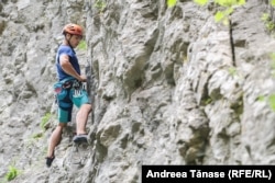 Cosmin Kandoi conduce un traseu de alpinism pe niște munți din sud-vestul României.