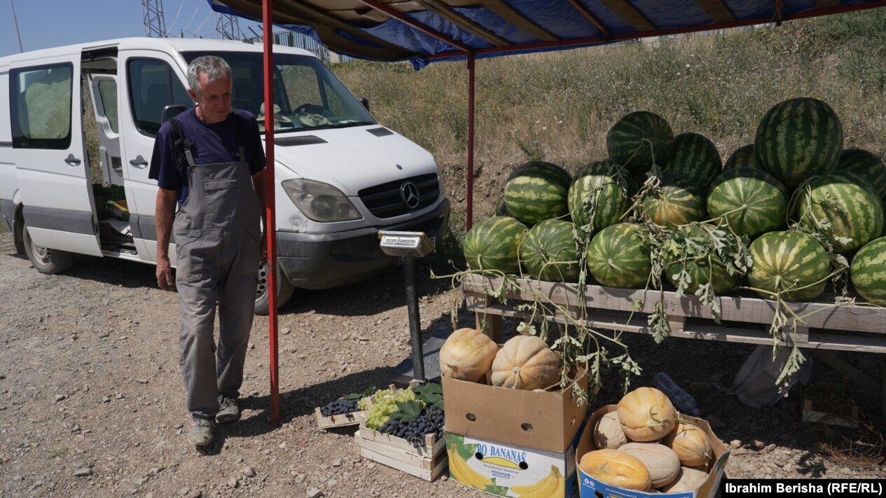 Ilvi Jupa pranë tezgës ku shet bostan dhe prodhime të tjera bujqësore.