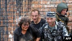 Un soldat ajută o femeie rănită în timpul operațiunii de salvare