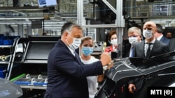 Orbán Viktor miniszterelnök emblémát ragaszt egy készülő autóra a győri Audi-gyárban 2020. június 15-én