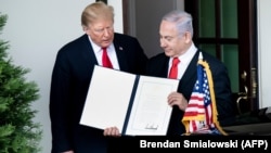 İsrailin baş naziri Benjamin Netanyahu (sağda) ABŞ prezidenti Donald Trump-ın Qolan təpələri barədə proklamasiyasına baxır