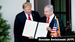 U.S. -- U.S. President Donald Trump (L) and Israeli Prime Minister Benjamin Netanyahu hold up a Golan Heights proclamation outside the West Wing after a meeting in the the White House in Washington, March 25, 2019