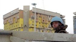 Војник на ИФОР (сили за спроведување) го надгледува градот со лхотел Холидеј Ин во позадина во Сараево, Босна и Херцеговина, 14 декември 1995 година.