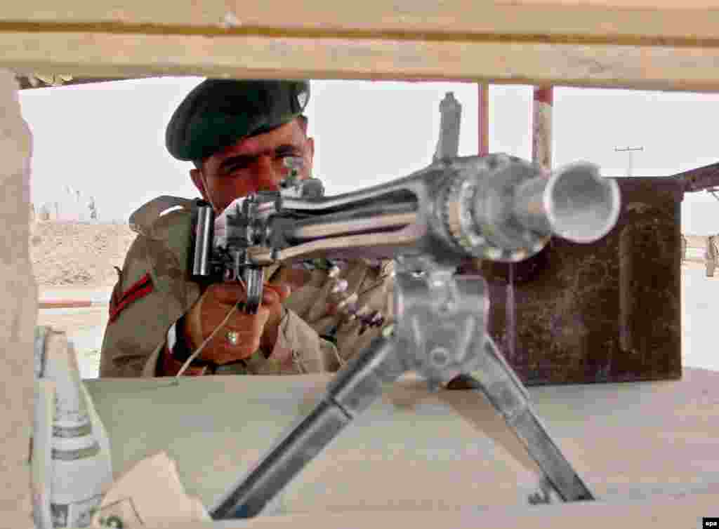 Afghnaistan/Pakistan -- A Pakistani Paramilitary soldier stands alert at the border crossing at Chaman, 30 Mar. 2006 - PAKISTAN AFGHANISTAN BORDER epa00680995 A Pakistani Paramilitary soldier stands alert at the border crossing at Chaman on Thursday 30 March 2006. Pakistani border forces seized some 150 kg of hashish after exchange of fire with Afghan smugglers who managed to escape. Pakistan, which has about 500,000 heroin users, is a major drug trafficking route from Afghanistan, by far the world's largest opium producer to central Asia and europe. Drug addiction is a major problem in both countries. EPA