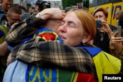 A Ukrainian woman embraces her husband after a prisoner swap in May.