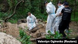 Forensic experts exhume the bodies of seven people near the village of Vorzel in the Kyiv region on June 13. According to police, they were all killed by shots to the head. Some of them had their hands tied.