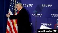 Дональд Трамп обіймає американський прапор після виступу в Лізбургу, штат Вірджинія, 7 листопада 2016 року
