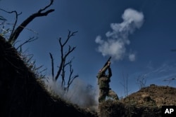 A Ukrainian soldier fires a grenade launcher on the front line in Bakhmut on April 10.