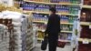 Serbia -- A woman looks at the price tags on merchandise in a government-backed discount supermarket in Belgrade, 23Apr2009