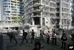 Spasioci i vojno osoblje na mjestu direktnog pogotka iranskog raketnog napada u Ramat Ganu, Izrael, u četvrtak, 19. juna 2025.