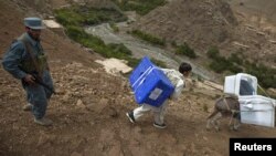 An Afghan policeman accompanies a man and a donkey carrying ballot boxes to a remote village in Panjshir Province, north of Kabul, for the 2010 elections.