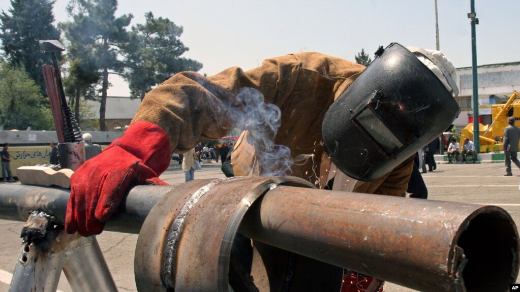 Iranian worker Amir Ghanbari welds a gas pipe at Tehran's Oil, Gas, Petrochemical Show, Iran, Thursday, April 20, 2006.