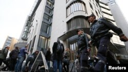 Журналистер жиналып тұрған сот ғимаратының жанынан өтіп бара жатқан норвегиялық полицейлер. Осло, 16 сәуір 2012 ж. Көрнекі сурет.