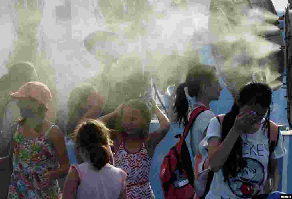 Children cool off in front of misting fans at the Australian Open on January 15.