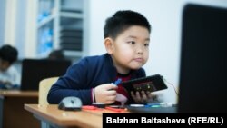 Kompýutere seredip oturan oglanjyk.