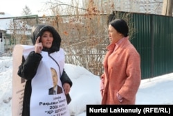 Farida Kabilbek férje szabadon engedéséért tüntet, miközben Rita Ermanova, az almati Medeu körzet belpolitikai osztályának munkatársa arra figyelmezteti, hogy a hatóságok előzetes engedélye nélküli tüntetésért felelősségre vonhatják. A kép 2020. január 14-én készült