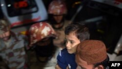 A man carries a boy injured after a bomb blast at a hospital in the Hub district, some 40 kilometers from Karachi on November 12. 