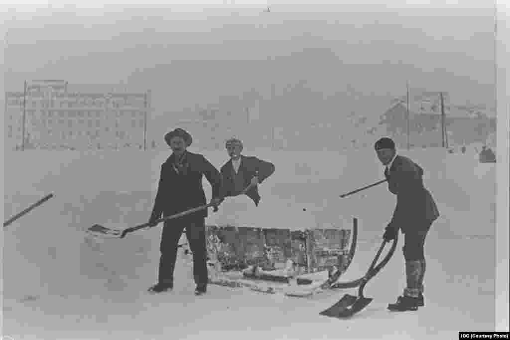 Staff clear snow in the Olympic Stadium