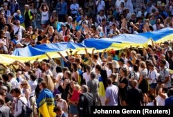 Люди несуть велетенський український прапор у День Незалежності України. Брюссель, Бельгія, 24 серпня 2022 року