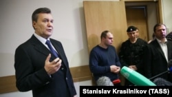 Бывший президент Украины Виктор Янукович (слева) общается с журналистами после выступления в Дорогомиловском суде