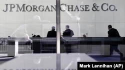 Люди стоят в вестибюле штаб-квартиры JPMorgan Chase в Нью-Йорке, 11 мая 2012 г.