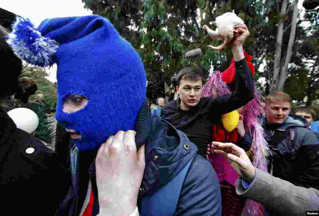 A man holding a raw chicken shouts slogans against members of punk performance collective Pussy Riot before the group speaks to journalists at the Sochi Winter Olympics in Adler on February 20. (Reuters/Eric Gaillard)